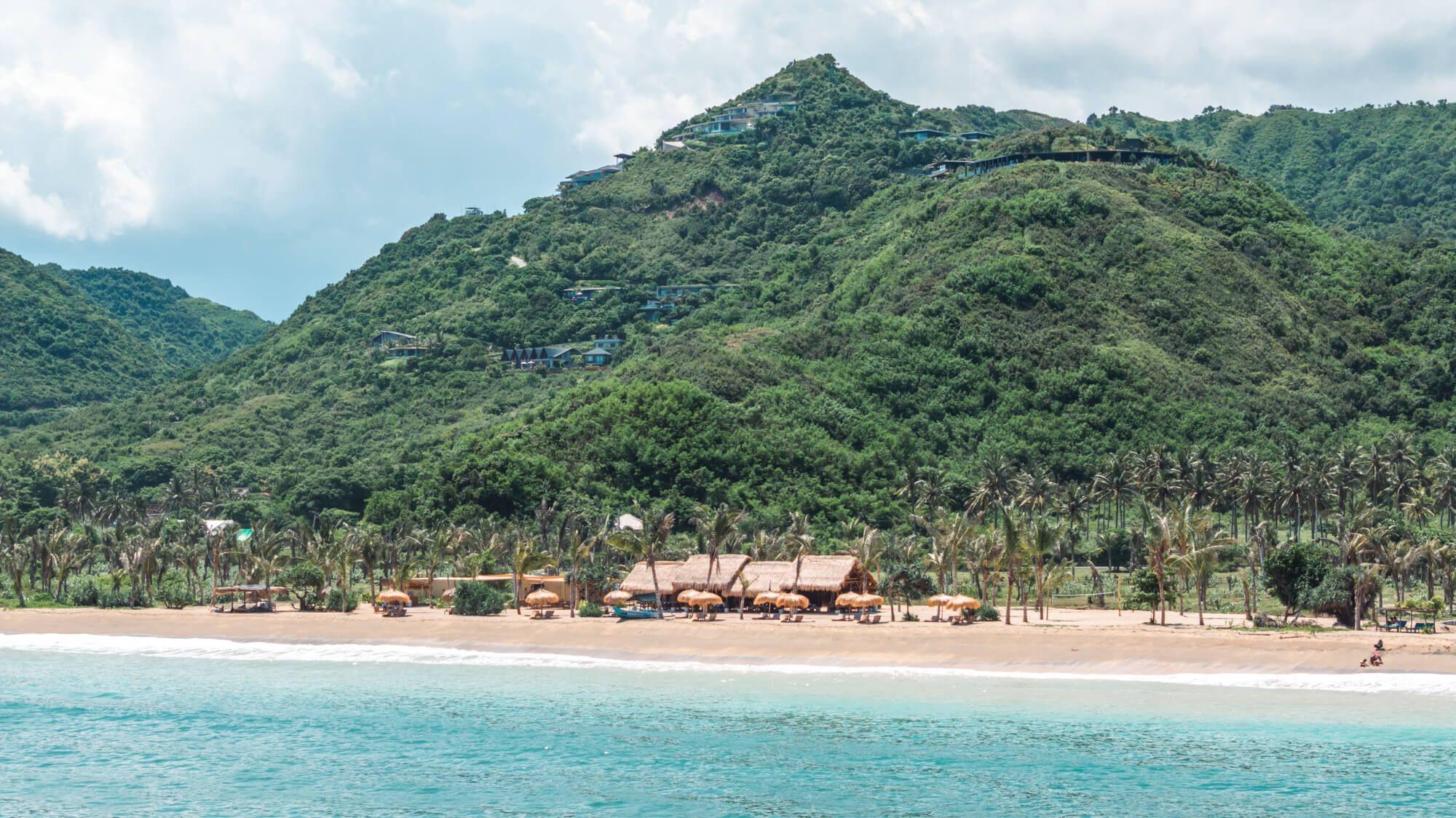Biras Beach Bar beneath green hills on Tampah Beach