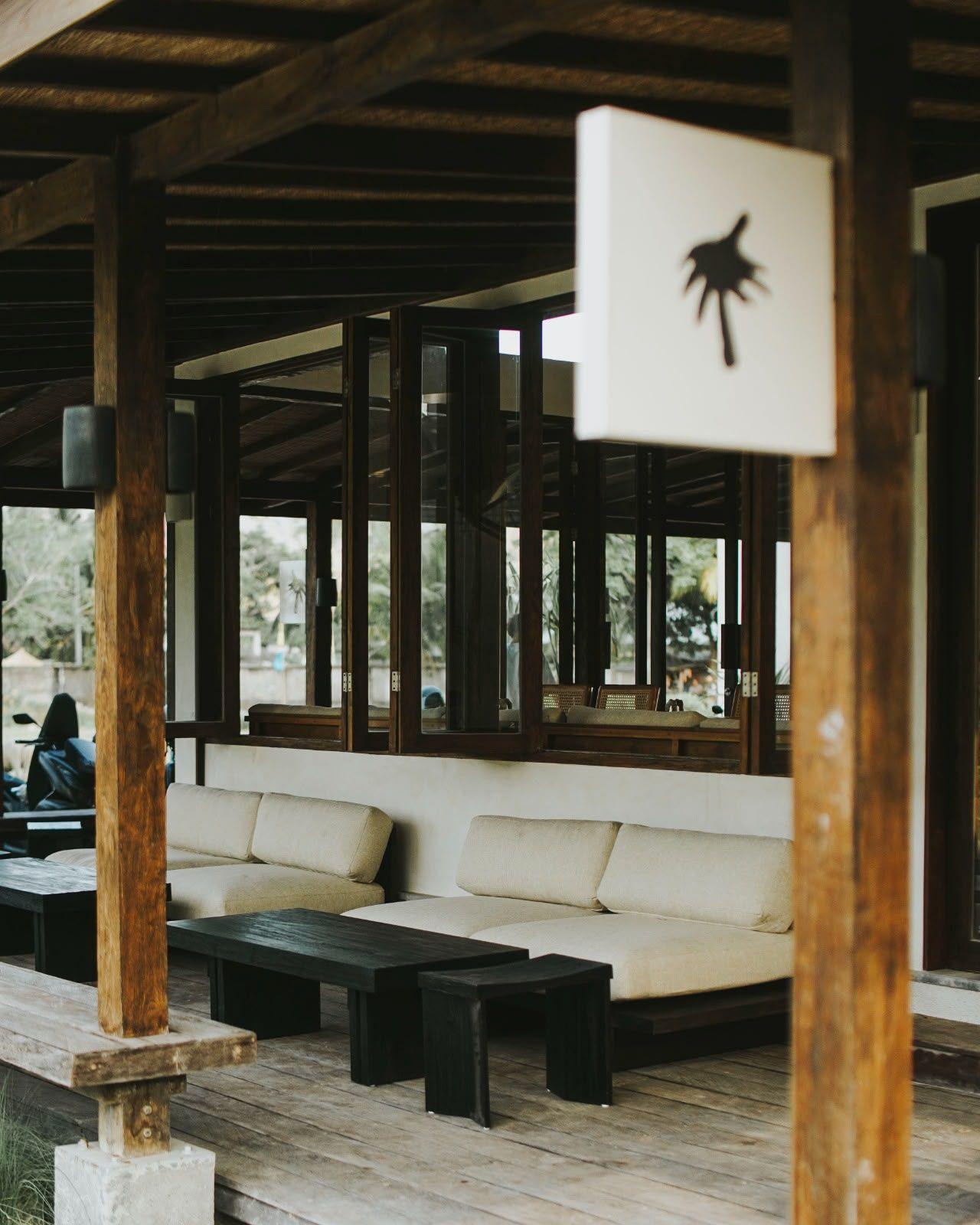 Shaded wooden terrace with cushioned seating at Sookla café in Selong Belanak